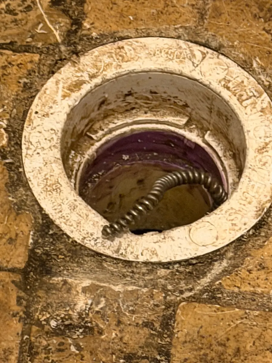 Drain snake working through a floor cleanout